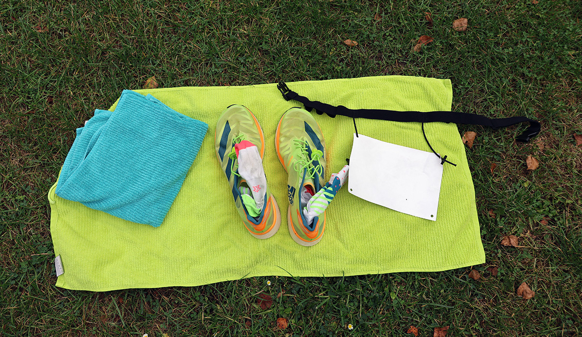 Beispielaufbau einer Wechselzone beim Swim & Run: Handtuch, Socken in Schuhen, Startnummernband